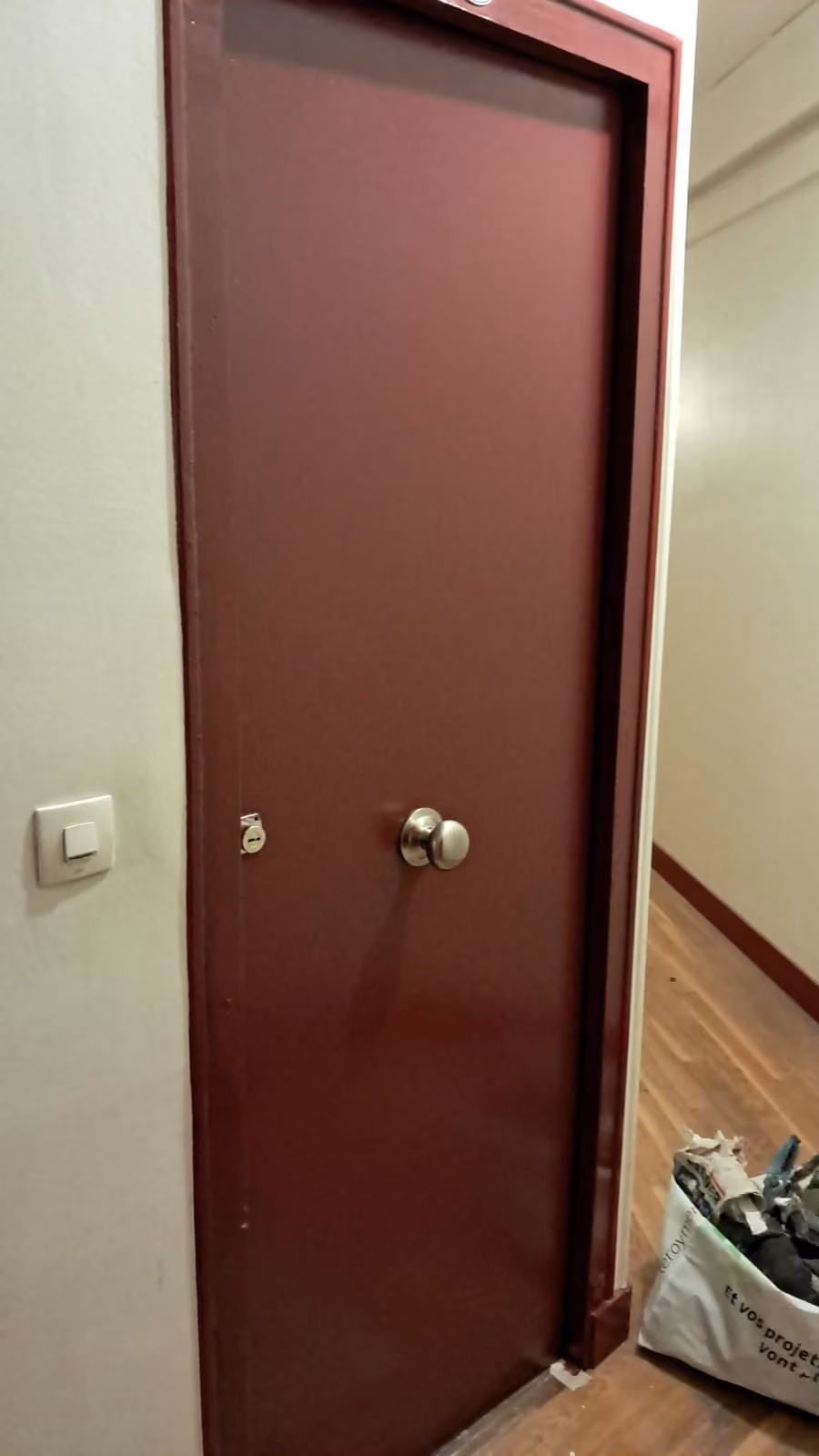 Porte blindée bordeaux avec bouton et cylindre de sécurité